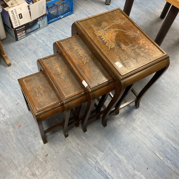Vintage Chinese nesting tables with intricate carved detailing.