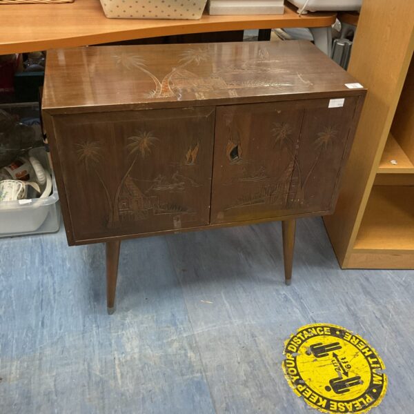 Front view of a vintage Chinese carved cabinet with tropical scene.