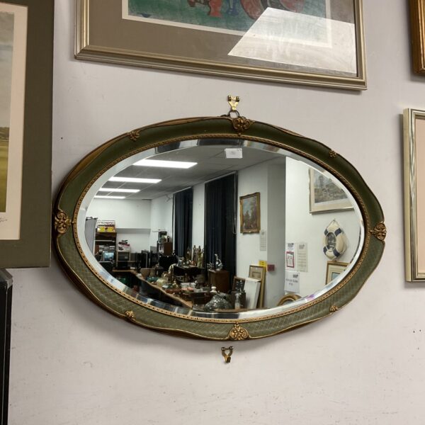 Vintage oval gilt mirror with bevelled edge and ornate frame.
