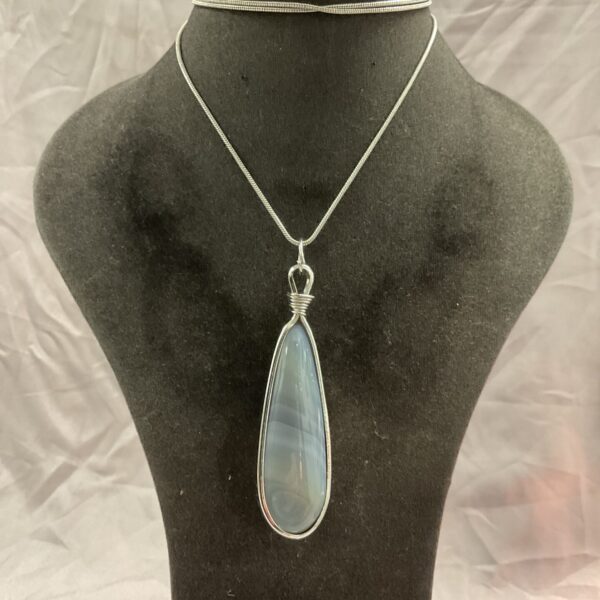 Vintage agate teardrop pendant on a long silver necklace.