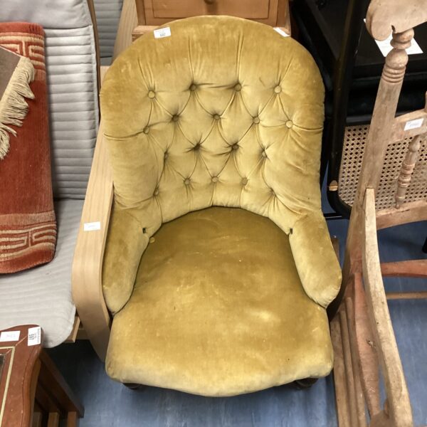 Vintage velvet nursing chair with curved back and arms.