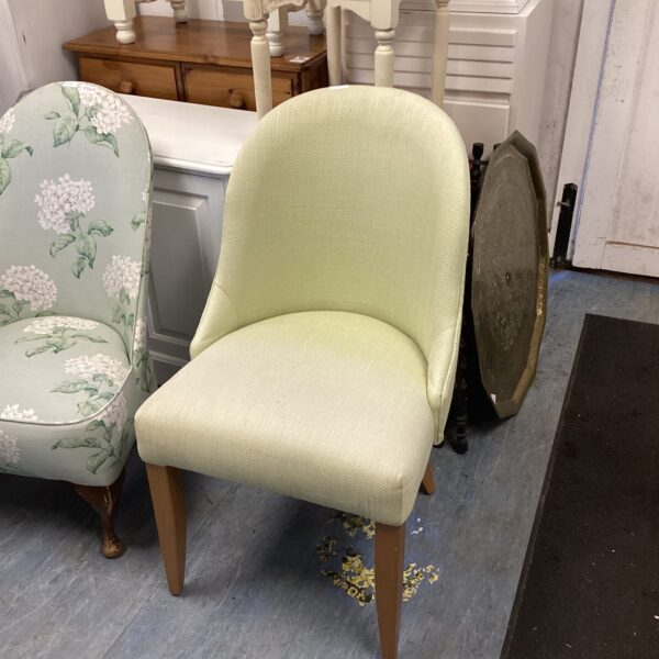 Pale green vintage nursing chair with floral upholstery.