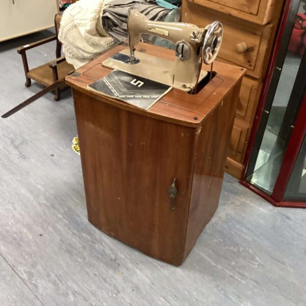 Vintage Viscount sewing machine cabinet in a home setting.