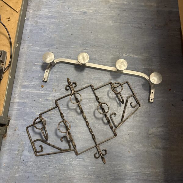 Vintage wrought iron coat rack with decorative hooks for entryway storage.