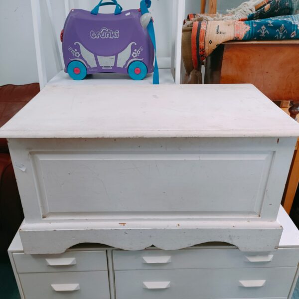 White chest of drawers with multiple drawers, vintage bedroom storage.