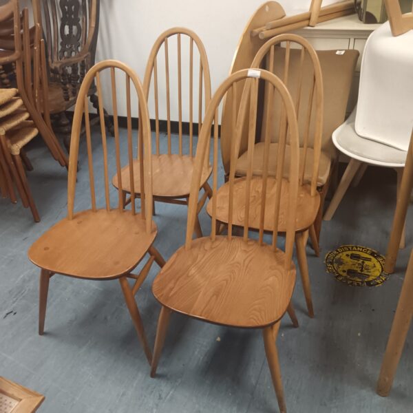 Set of four vintage Ercol Windsor stick back chairs in blonde wood.