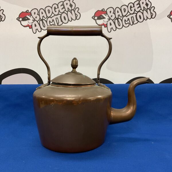 Antique copper kettle with a darkened patina, vintage kitchenalia.