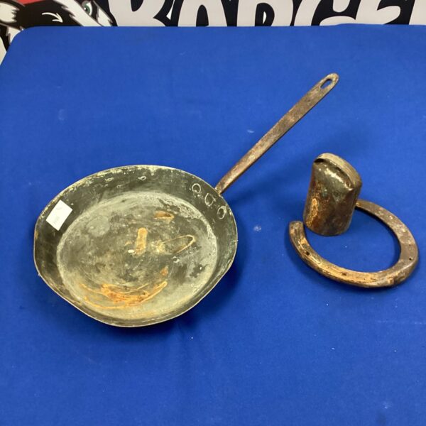 Antique copper pan, horseshoe, and cow bell in a vintage lot.