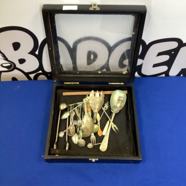 Vintage silverplate tableware set with ornate designs and sugar tongs.