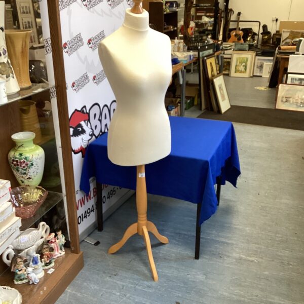Vintage dressmaker manikin with wooden stand, ideal for display.