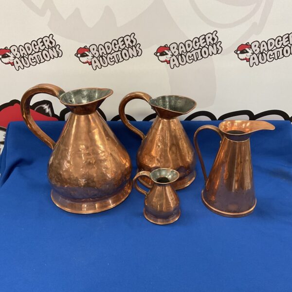 Lot of three antique copper jugs with varying styles.