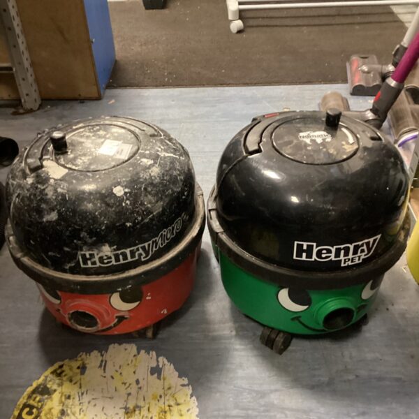 Two red and black Henry vacuum cleaners in an auction lot.