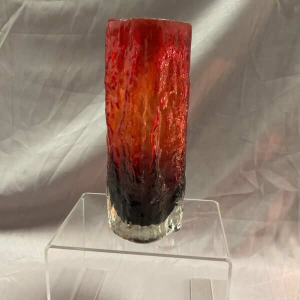 Red and black Tajima style glass vase on a clear stand.