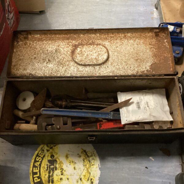 Vintage metal tool box filled with various hand tools.