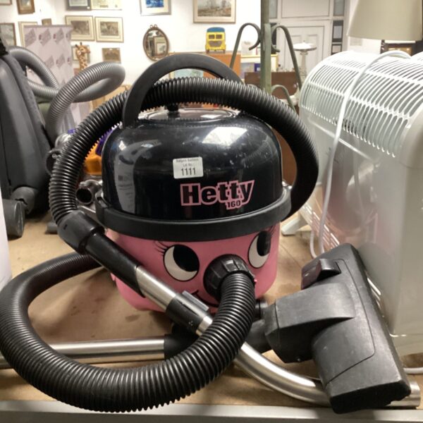 Front view of a vintage Hetty vacuum cleaner with hose attached.