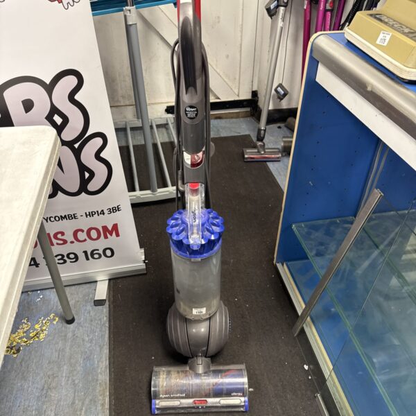 Dyson Ball DC65 upright vacuum cleaner in a cluttered environment.