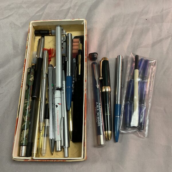Assorted vintage pens including Parker and Harrods in a box.