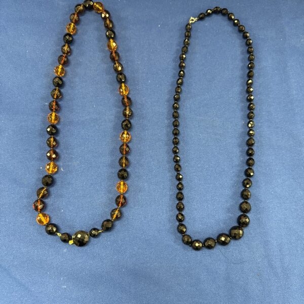 Vintage costume jewellery necklaces featuring orange and dark beads.