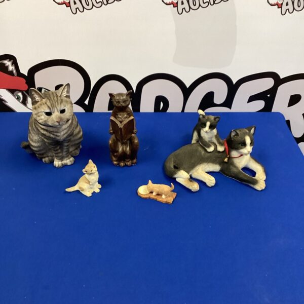 Collection of vintage porcelain cat figurines on display.