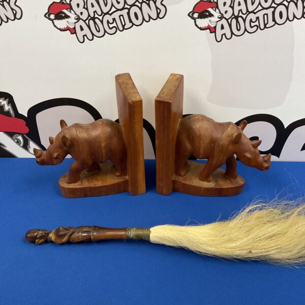 Vintage carved wooden rhino bookends with African fly swatter.