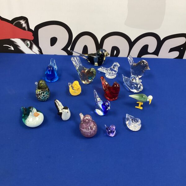 Colourful glass bird paperweights in a collectible lot.