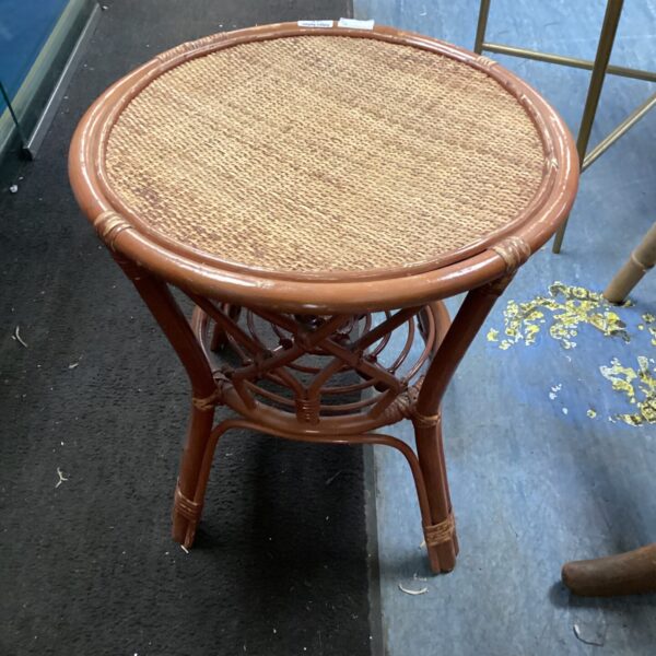 Vintage woven top side table with rattan legs.