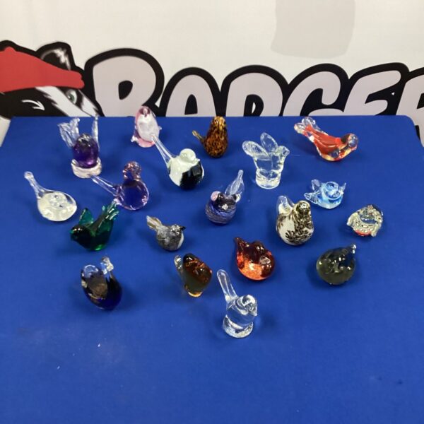 Colourful glass bird paperweights in a collectible lot.