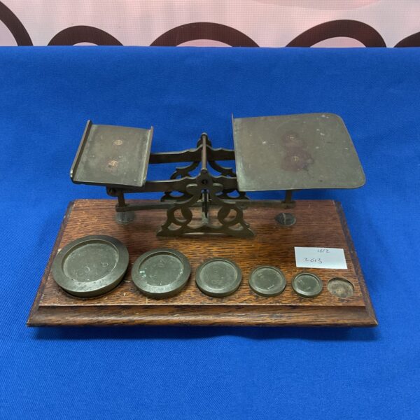 Vintage letter scales with brass weights on wooden base.