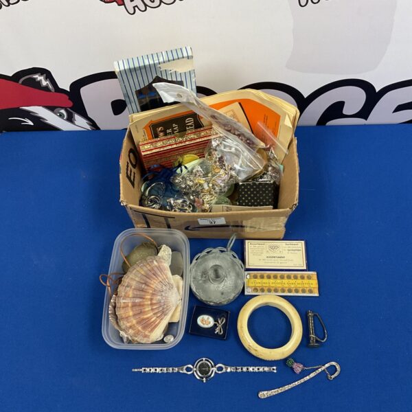 Mixed lot of vintage jewellery and curios in a cardboard box.