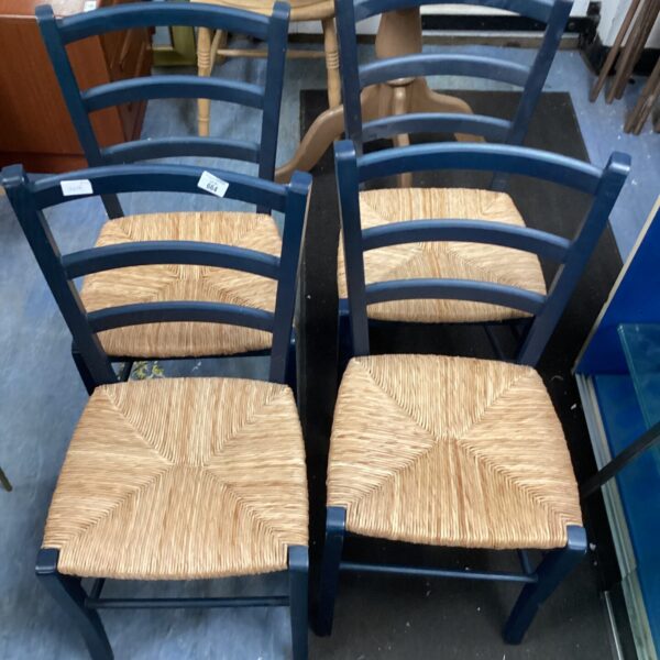 Set of four vintage bullrush rattan chairs with woven seats.