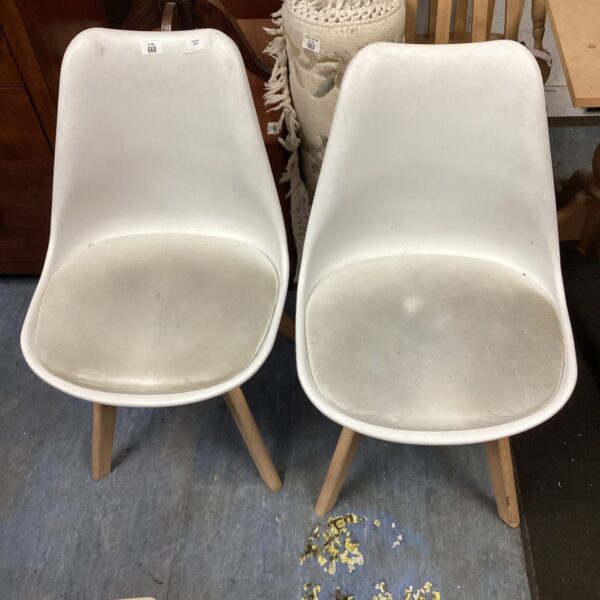 Pair of white designer dining chairs with wooden legs.