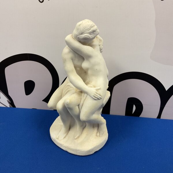 Vintage plaster sculpture of lovers embracing, romantic art.