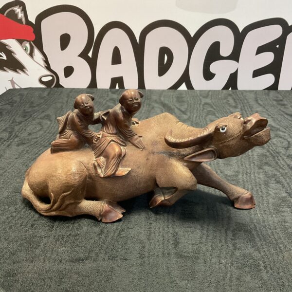 Vintage carved water buffalo figurine with riders, detailed oriental sculpture.