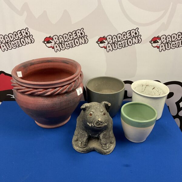 Garden pots and concrete pig ornament for outdoor display.
