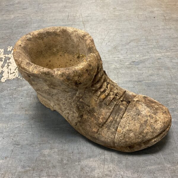 Rustic concrete boot planter for garden plants and outdoor decor.