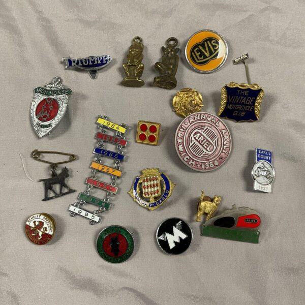 Vintage collection of motorcycle pin badges including Ariel and Triumph.