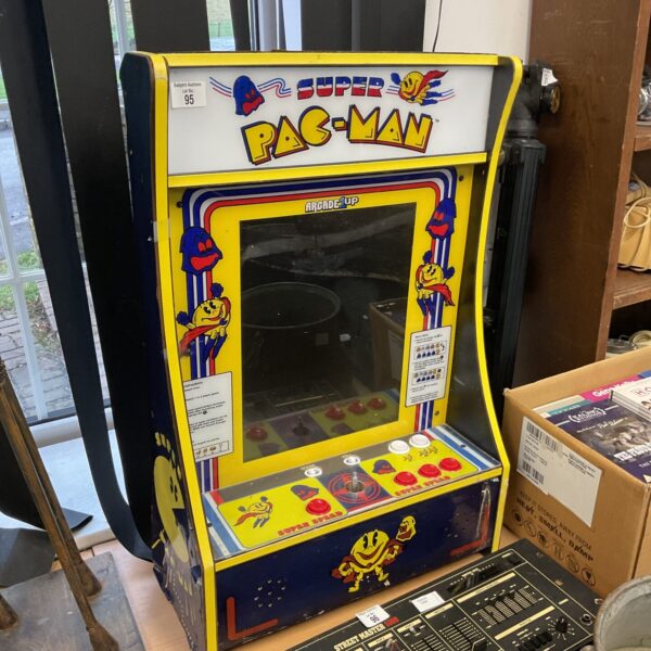 Vintage Super Pac-Man arcade machine in a collector's setting.