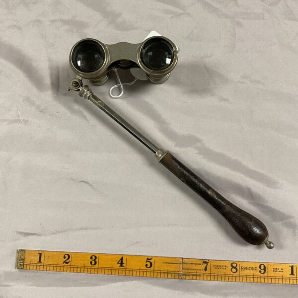 Antique opera glasses with telescopic handle, front view.