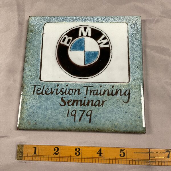 Vintage 1979 BMW dealer tile with logo and text.