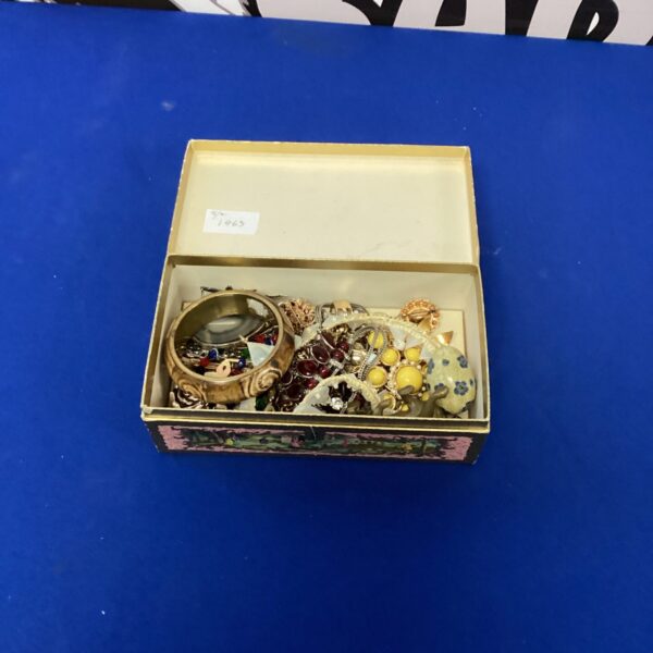 Vintage jewellery box filled with assorted costume jewellery pieces.