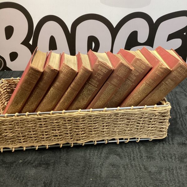 Vintage Charles Dickens books displayed in a wicker basket.