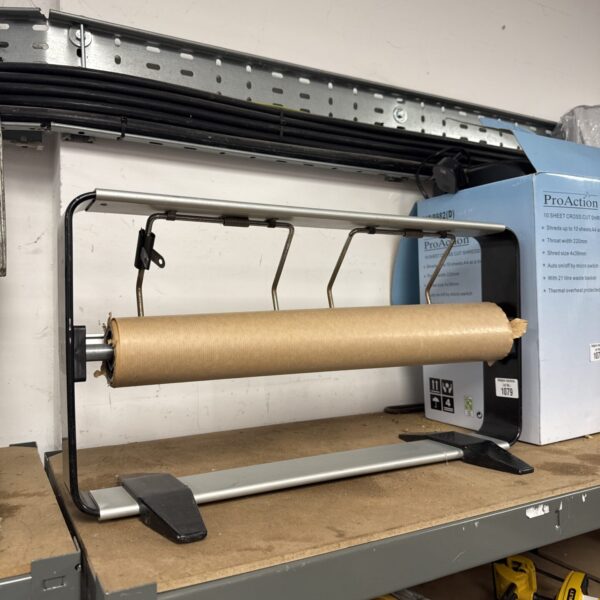 Metal commercial wrapping paper dispenser with partial roll.