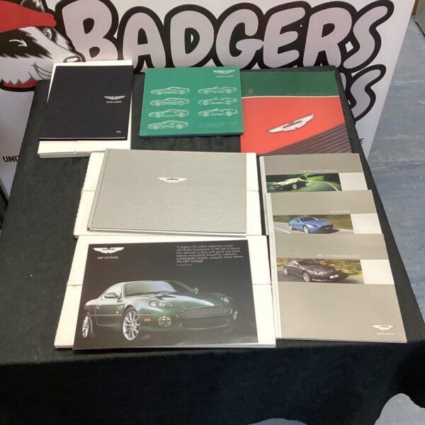 Stack of vintage Aston Martin brochures for collectors.