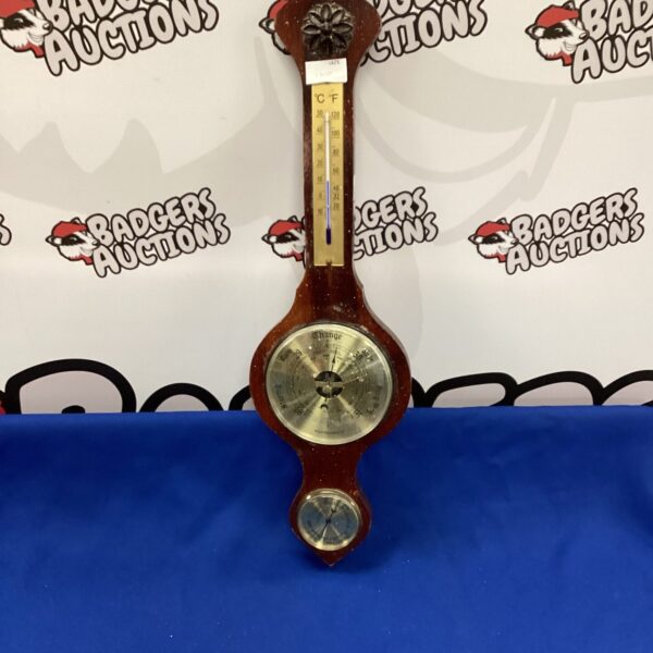 Vintage wooden framed barometer for measuring weather conditions.