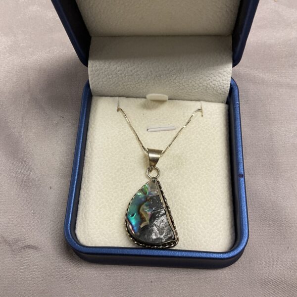 Silver necklace with iridescent abalone shell pendant.