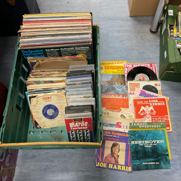 Mixed lot of vinyl records and VHS tapes for music lovers.