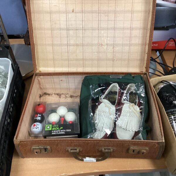 Vintage golf suitcase with golf shoes inside, retro sporting goods.