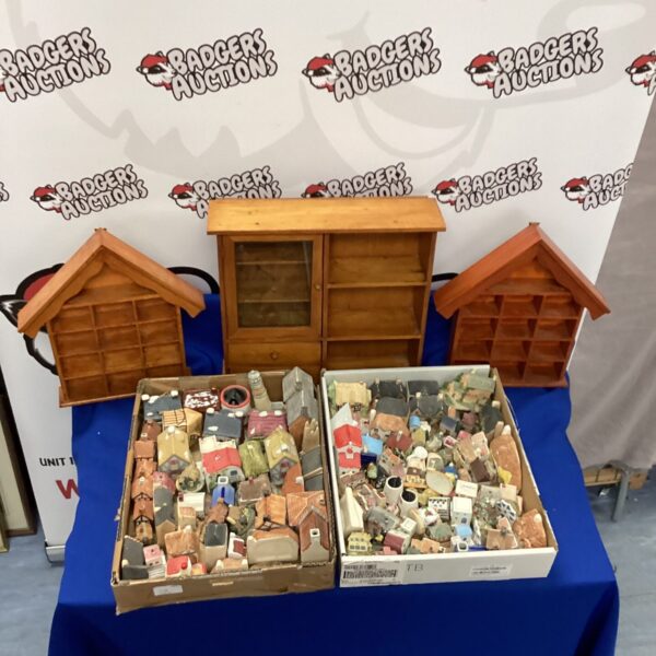 Large collection of miniature houses and cottages in display cases.