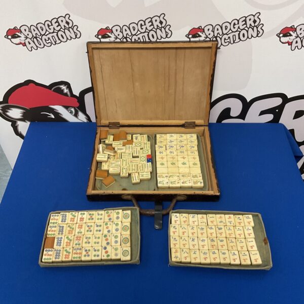 Antique bone mahjong set with traditional tiles in wooden case.