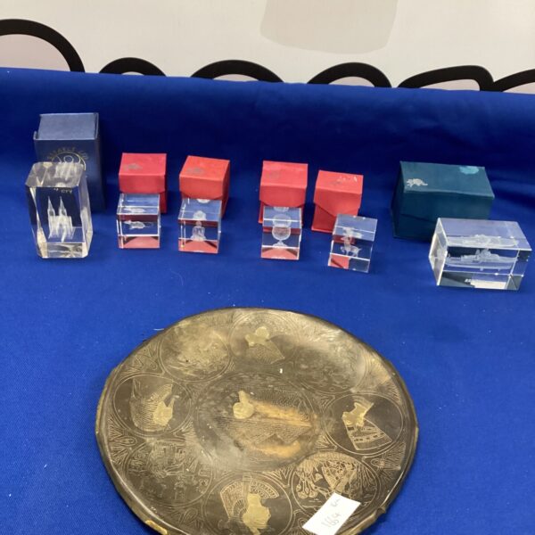 Glass paperweight collection displayed on a metal tray.